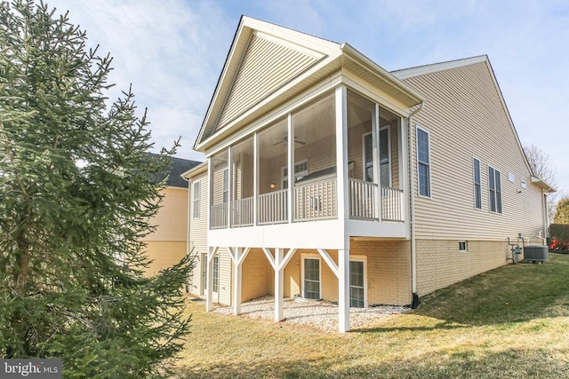 view of home's exterior with a sunroom, central AC, ceiling fan, and a lawn