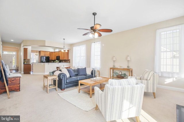 carpeted living room featuring ceiling fan