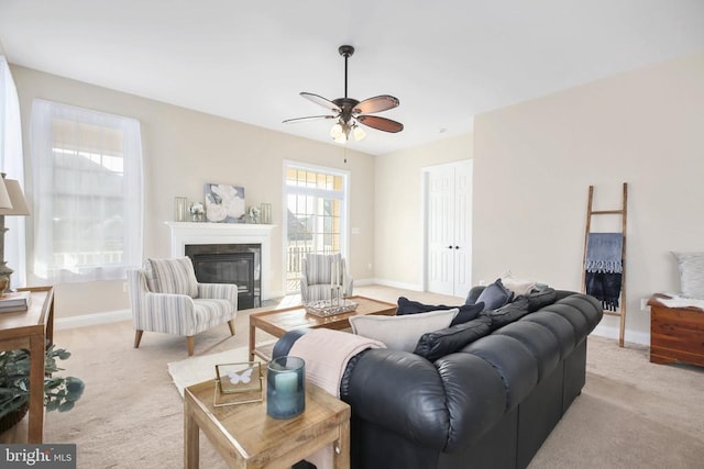 living room with ceiling fan, a fireplace, and light carpet