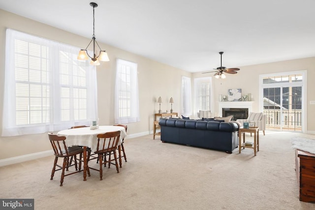 carpeted dining space with ceiling fan