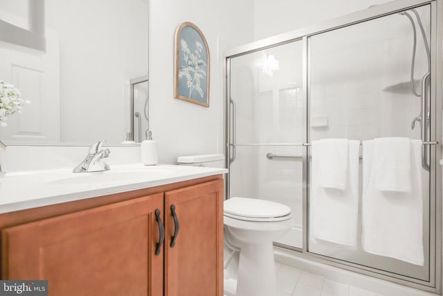 bathroom featuring vanity, toilet, tile patterned flooring, and a shower with door