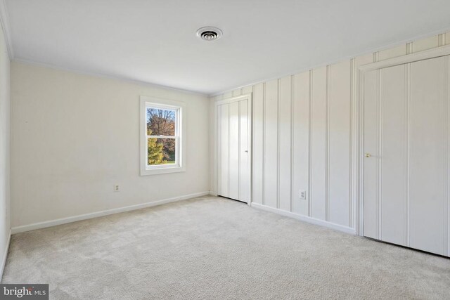 unfurnished bedroom featuring light colored carpet and a closet