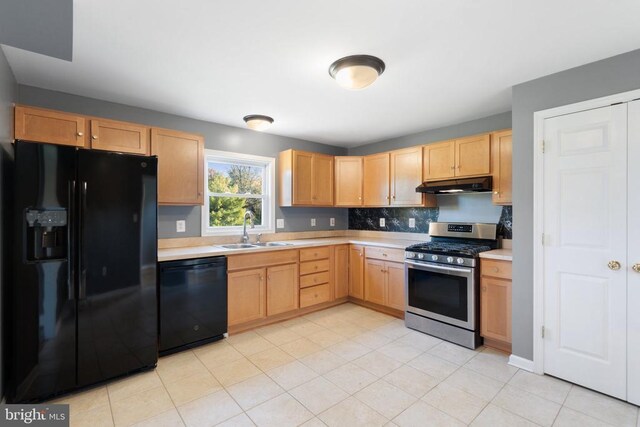 kitchen with light brown cabinetry, tasteful backsplash, sink, light tile patterned floors, and black appliances