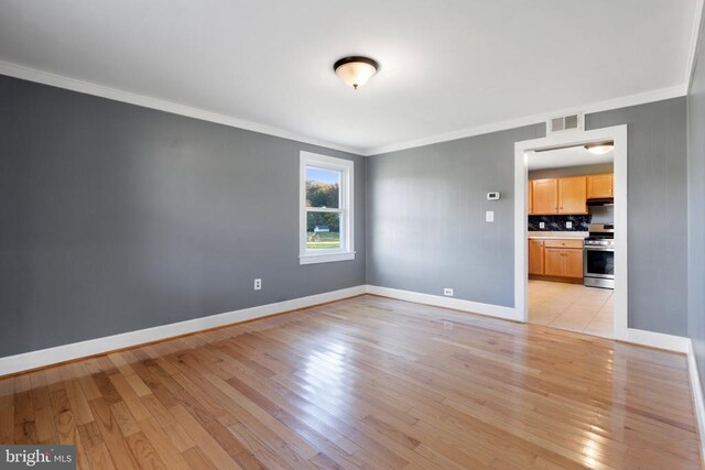 unfurnished living room featuring crown molding and light hardwood / wood-style flooring