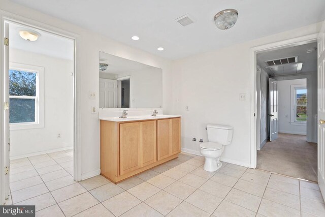 bathroom with tile patterned flooring, vanity, and a healthy amount of sunlight