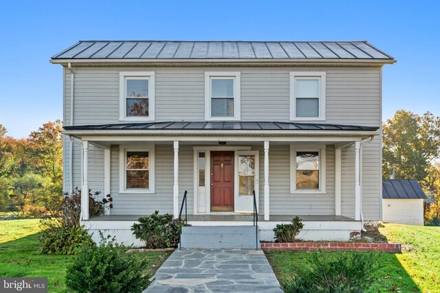 view of front of home with a porch and a front lawn