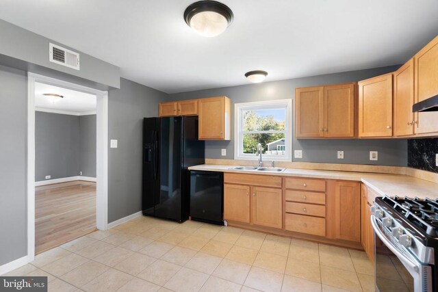 kitchen featuring light tile patterned flooring, sink, and black appliances