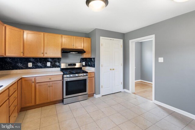 kitchen featuring decorative backsplash, stainless steel range with gas stovetop, and light tile patterned flooring