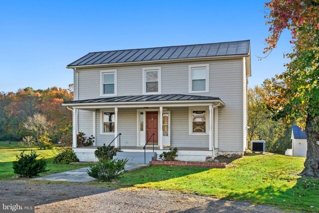 view of front of home featuring central AC unit, a front lawn, and covered porch