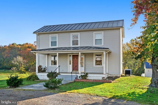 view of front of home featuring central AC unit, a front lawn, and covered porch