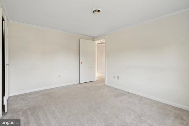 unfurnished room with ornamental molding and light carpet