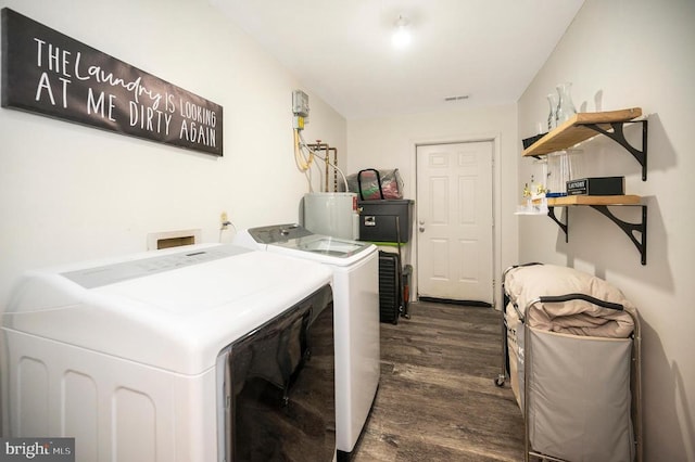 laundry room with dark wood finished floors, laundry area, washing machine and dryer, and water heater