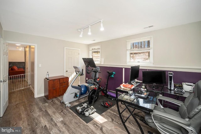 office space with visible vents, rail lighting, baseboards, and wood finished floors