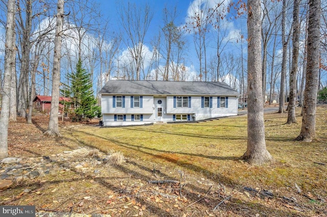 raised ranch featuring entry steps and a front lawn