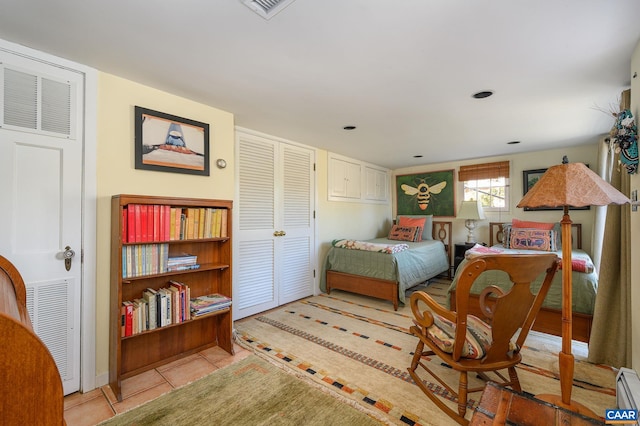 tiled bedroom featuring visible vents and a baseboard heating unit