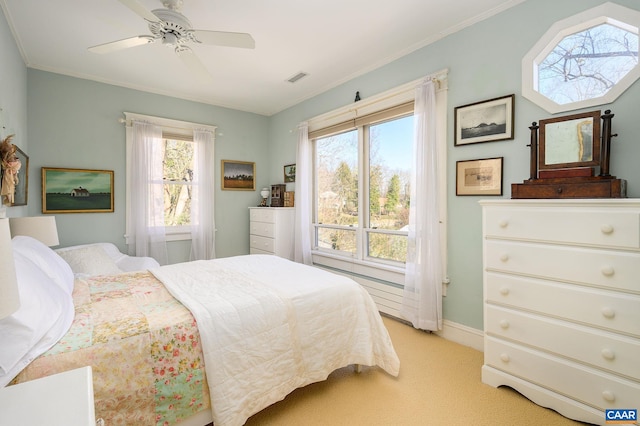 bedroom featuring light carpet, ornamental molding, visible vents, and a ceiling fan