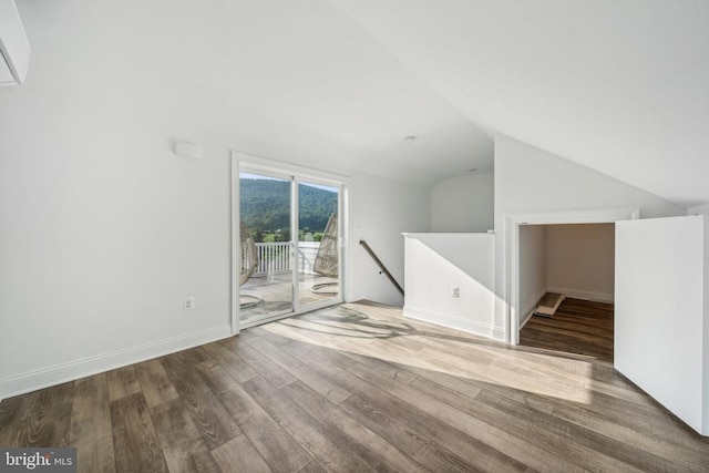 unfurnished living room with hardwood / wood-style floors and vaulted ceiling