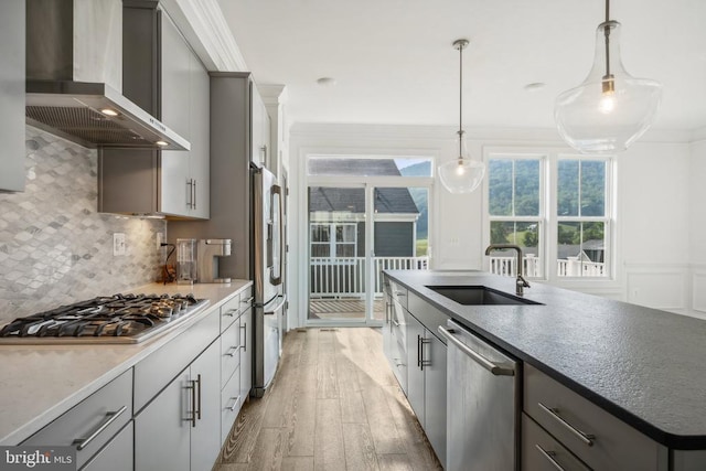 kitchen featuring gray cabinetry, wall chimney exhaust hood, and appliances with stainless steel finishes