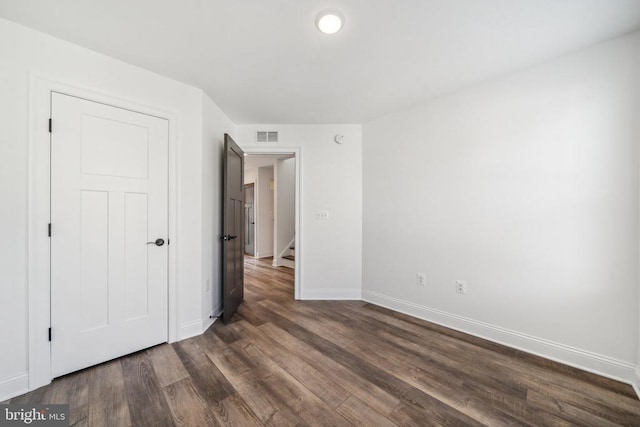 unfurnished bedroom with dark wood-type flooring