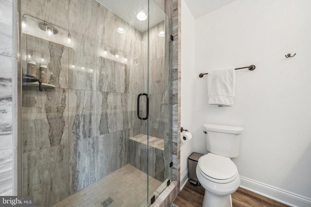 bathroom featuring hardwood / wood-style floors, toilet, and walk in shower