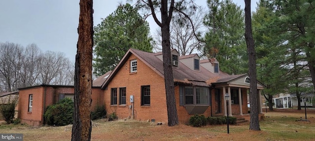 view of front of property with brick siding and a shingled roof