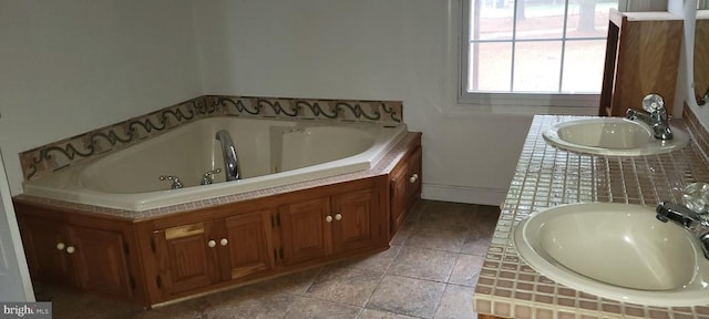 full bath featuring a bath, tile patterned flooring, and a sink