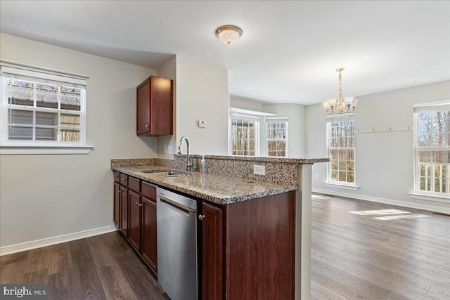 kitchen with dark wood-type flooring, stone counters, a peninsula, stainless steel dishwasher, and a sink