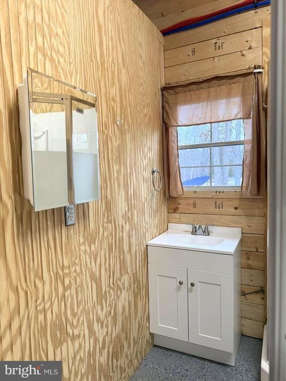 bathroom with vanity and wooden walls