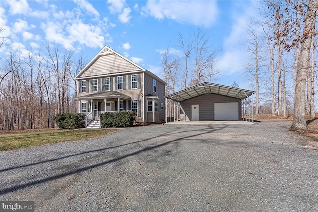 view of front of property featuring an outbuilding, a porch, a detached garage, and driveway