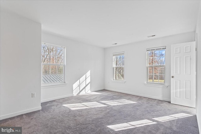 carpeted empty room with baseboards and visible vents