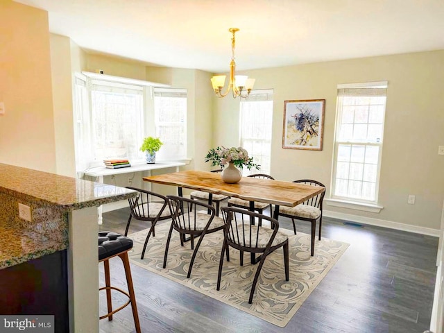 dining room featuring plenty of natural light, dark wood-style floors, and a chandelier