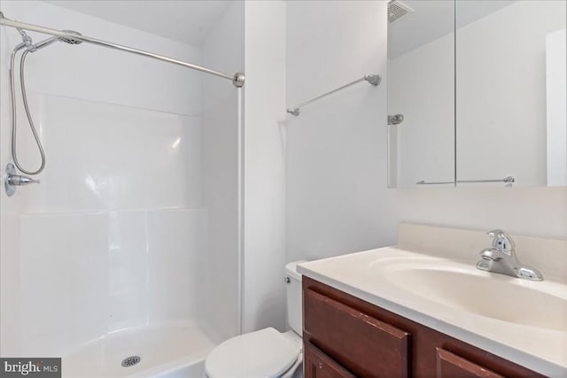 bathroom featuring visible vents, toilet, a stall shower, and vanity