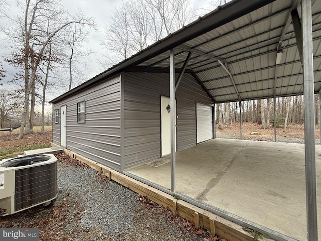 view of side of home with an outbuilding, central AC, and a carport