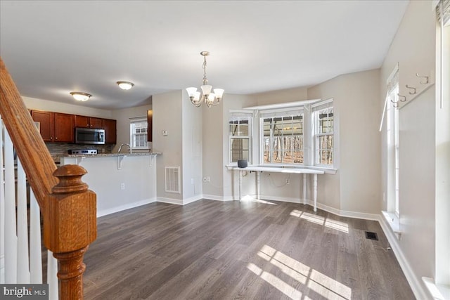 interior space featuring stairs, dark wood-type flooring, a notable chandelier, and visible vents