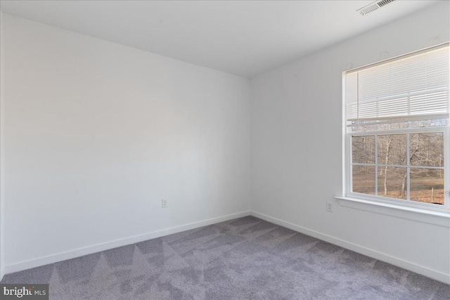 unfurnished room featuring visible vents, baseboards, and carpet