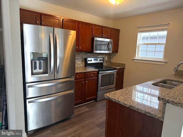 kitchen with sink, backsplash, stainless steel appliances, dark hardwood / wood-style floors, and light stone countertops