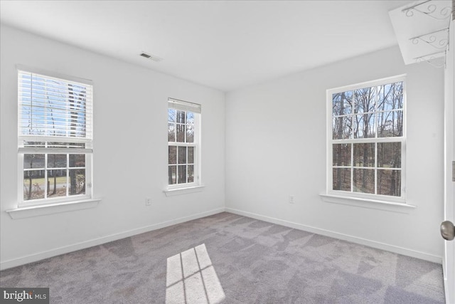 spare room with visible vents, baseboards, and carpet