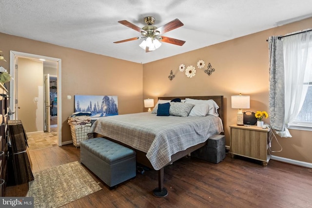 bedroom featuring ceiling fan, radiator heating unit, dark hardwood / wood-style flooring, and multiple windows