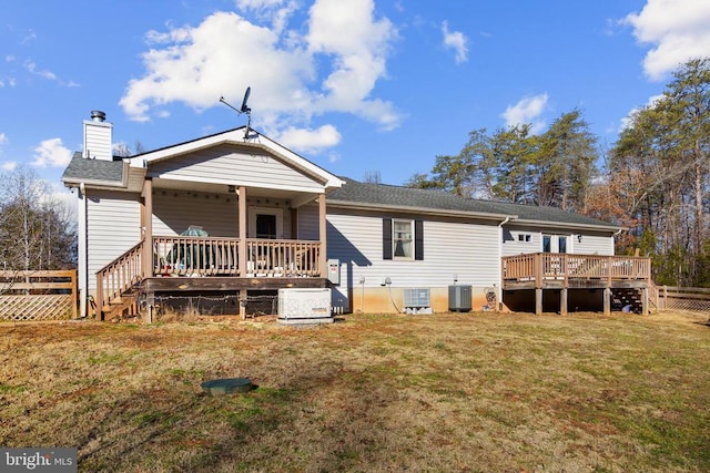 rear view of house with central AC unit, a yard, and a deck