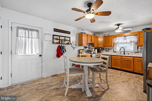 kitchen featuring ceiling fan, appliances with stainless steel finishes, sink, and a textured ceiling