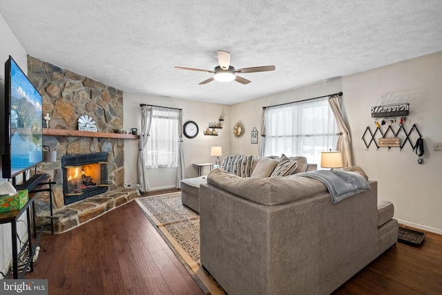 living room featuring dark wood-type flooring, a fireplace, and a wealth of natural light