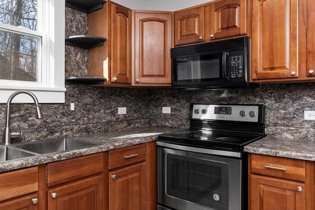 kitchen with dark stone counters, sink, stainless steel range with electric cooktop, and backsplash