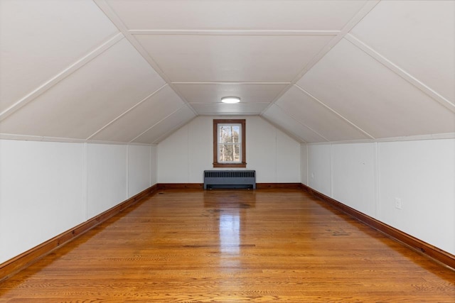 bonus room featuring lofted ceiling, radiator, and light hardwood / wood-style flooring