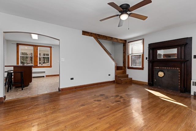 living room featuring ceiling fan, radiator, and light hardwood / wood-style flooring