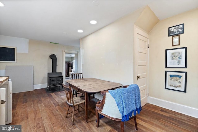 dining area with dark hardwood / wood-style flooring and a wood stove