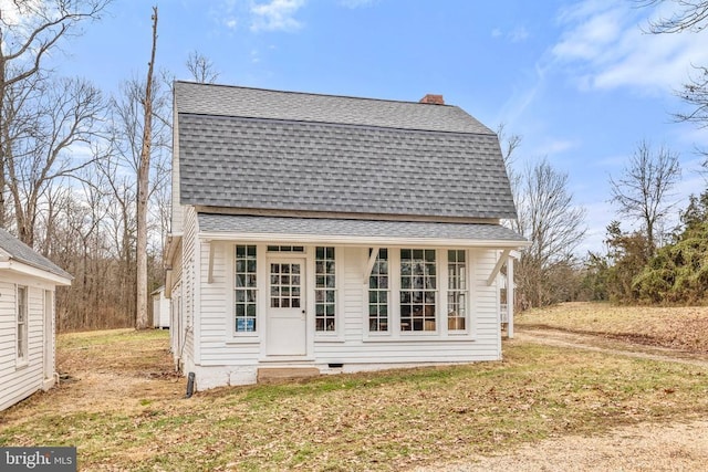 back of property with an outbuilding and a lawn