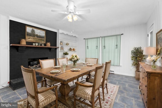 dining space with ceiling fan, a brick fireplace, baseboard heating, and built in shelves