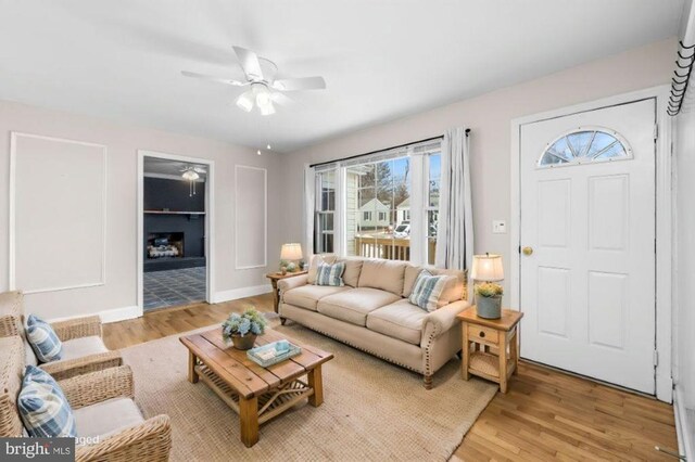 living room featuring ceiling fan and light hardwood / wood-style flooring