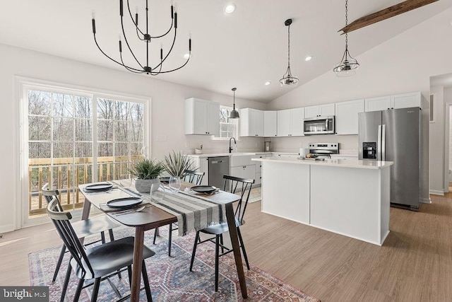 dining area featuring an inviting chandelier, beamed ceiling, recessed lighting, and light wood-type flooring