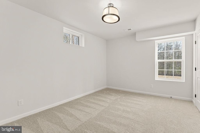 carpeted spare room featuring visible vents and baseboards